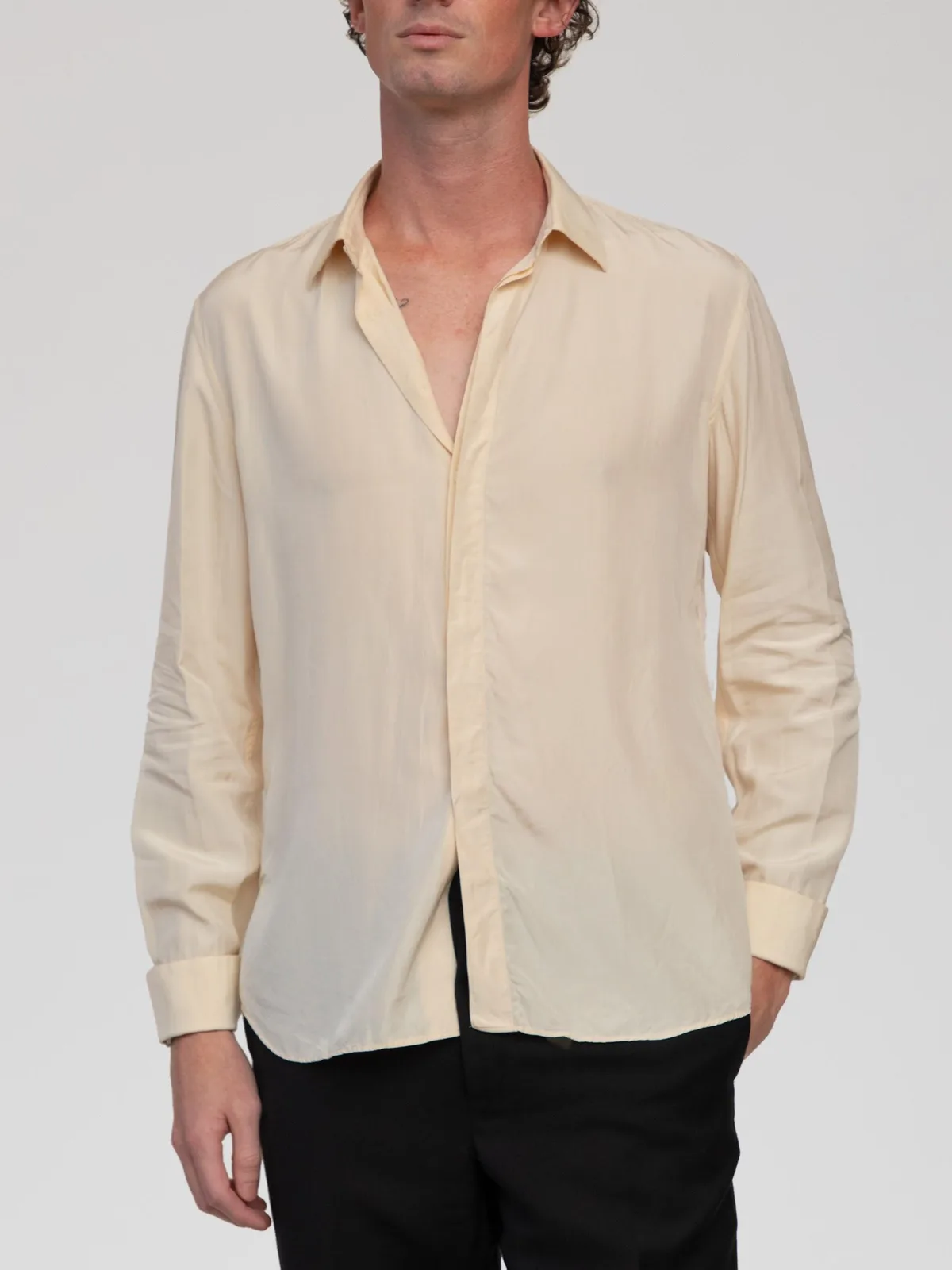Vintage Valentino Chemises pale cream silk long-sleeve dress shirt featuring a classic point collar, a concealed button-front placket, single-button barrel cuffs, and a subtly curved hemline. Made in Italy.