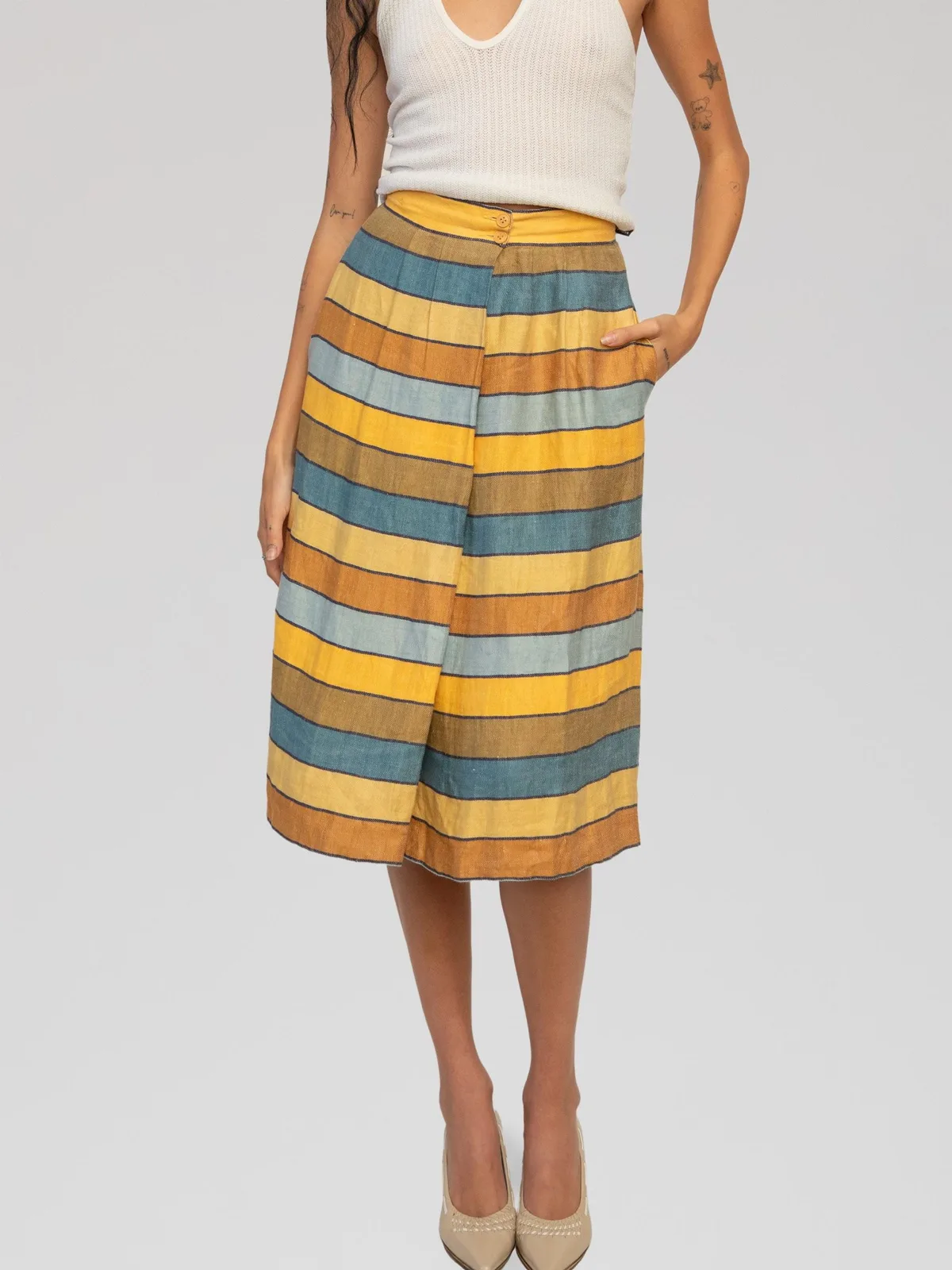 Vintage Christian Dior Tricots et Coordonnés A-line midi skirt featuring a horizontal striped pattern in yellow, ochre, blue, and light blue tones, detailed with a fitted waistband and side pockets.