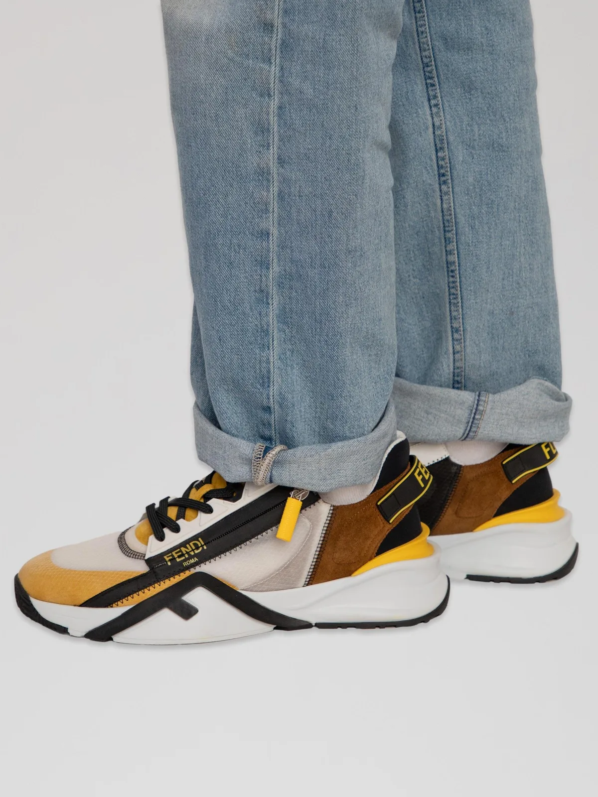 Fendi Flow low-top sneakers Mens 11 crafted in a multi-material paneled design featuring a mix of white mesh, yellow and brown suede overlays, black leather detailing, a diagonal side-zip closure with a branded pull tab, branded heel pulls with "FENDI FLOW" lettering, and a sculpted chunky rubber sole with an embossed FF motif at the lateral wall.