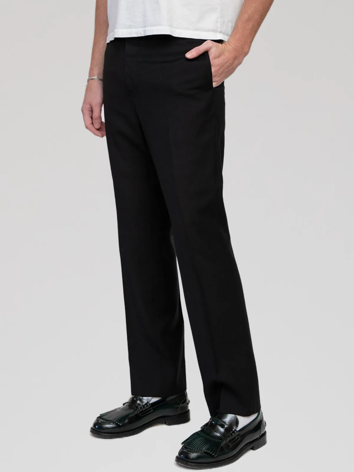 Hedi Slimane Era Dior Homme black tailored dress trousers featuring a slim, straight-leg silhouette with sharp pressed leg creases, side slip pockets, rear welt pockets, a concealed zip fly, and a tab closure waistband. Crafted in Italy from 100% Super 100s wool with a Bemberg lining.